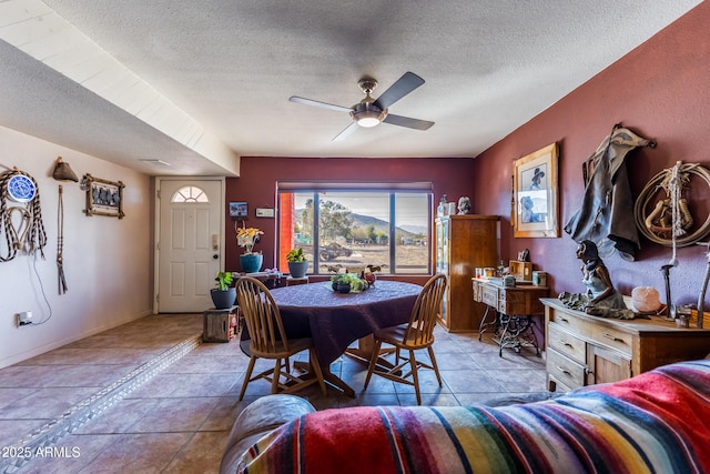 tiled dining space featuring a textured ceiling and ceiling fan