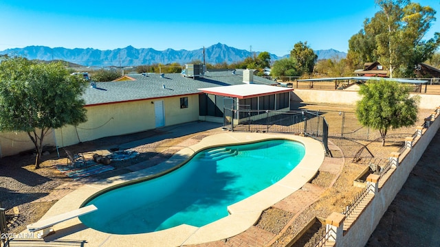 view of swimming pool featuring a mountain view, a diving board, central AC, and a patio