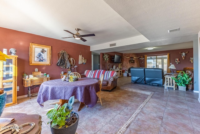 dining room featuring ceiling fan, tile patterned floors, and a textured ceiling