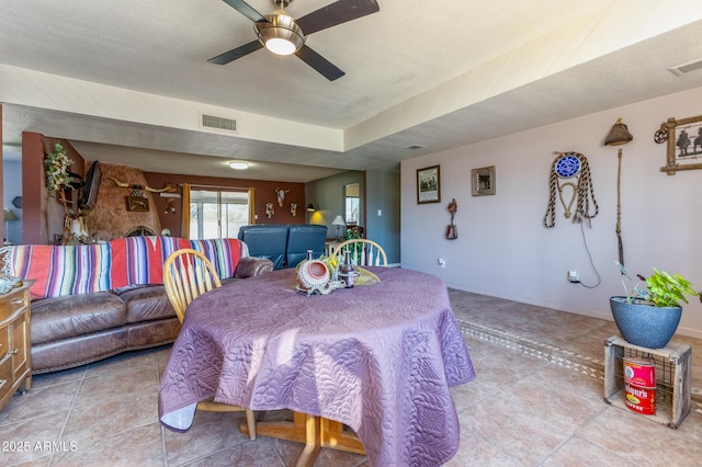 tiled dining area with ceiling fan and a textured ceiling