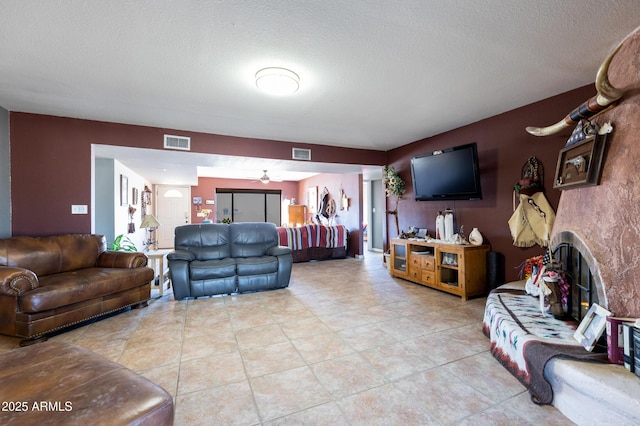 tiled living room featuring a fireplace and a textured ceiling