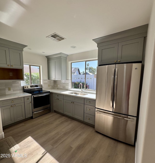 13601 N 50th Pl, Scottsdale, AZ 85254 - kitchen with stainless steel appliances, a sink, gray cabinetry, wood finished floors, and light countertops