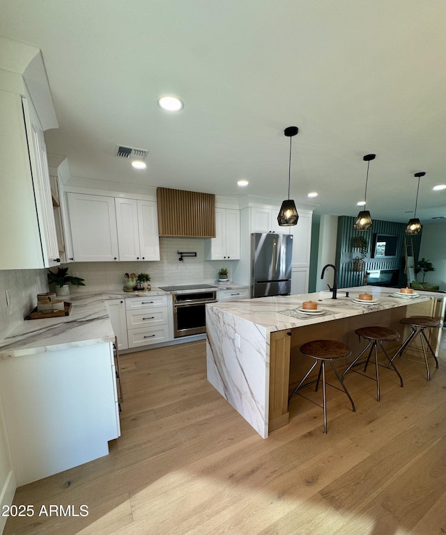 13601 N 50th Pl, Scottsdale, AZ 85254 - kitchen featuring stainless steel appliances, decorative backsplash, light wood finished floors, white cabinets, and recessed lighting