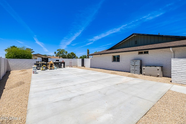 13601 N 50th Pl, Scottsdale, AZ 85254 - view of side of property with a patio area, board and batten siding, a fenced backyard, and a playground