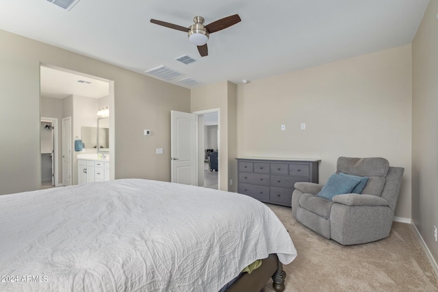 carpeted bedroom with ensuite bathroom and ceiling fan