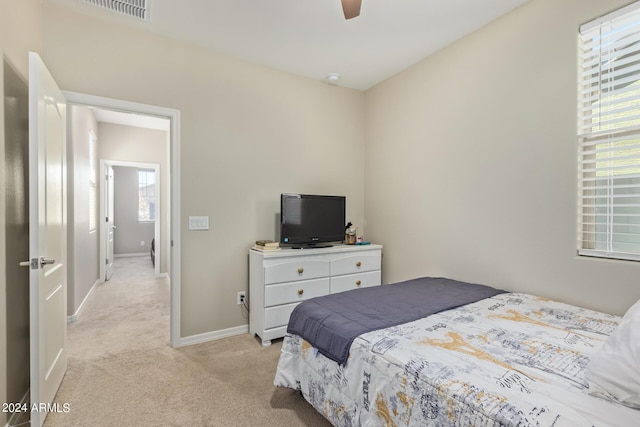 carpeted bedroom featuring ceiling fan and multiple windows