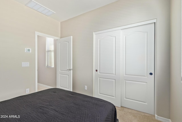 unfurnished bedroom featuring light colored carpet and a closet