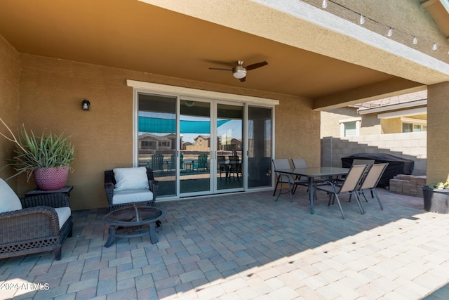 view of patio with ceiling fan and an outdoor fire pit