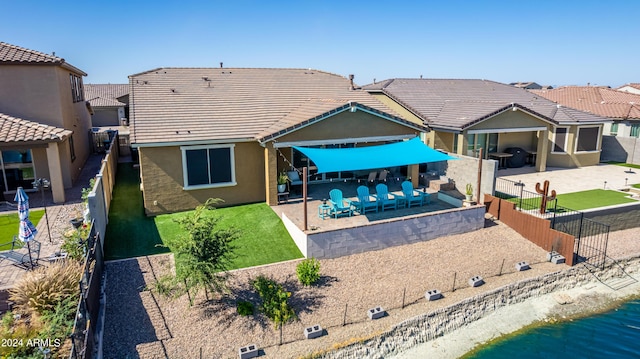 back of property featuring a water view and a patio