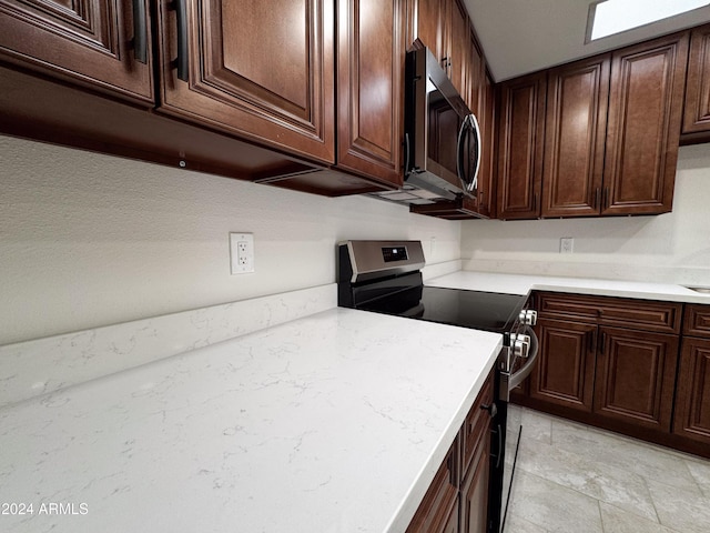 kitchen with dark brown cabinets and appliances with stainless steel finishes