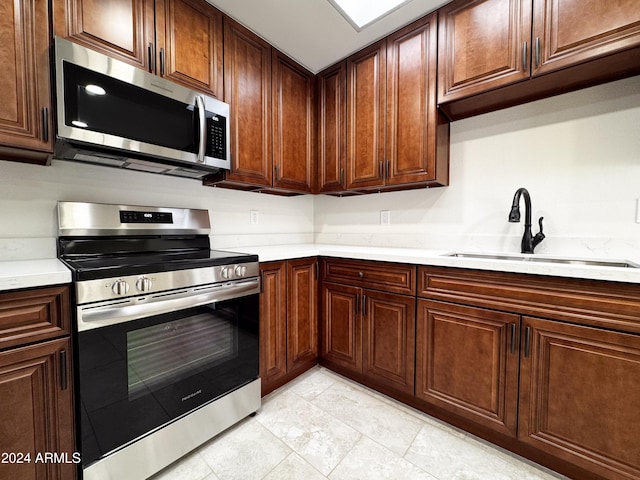 kitchen featuring sink, light tile patterned floors, and stainless steel appliances