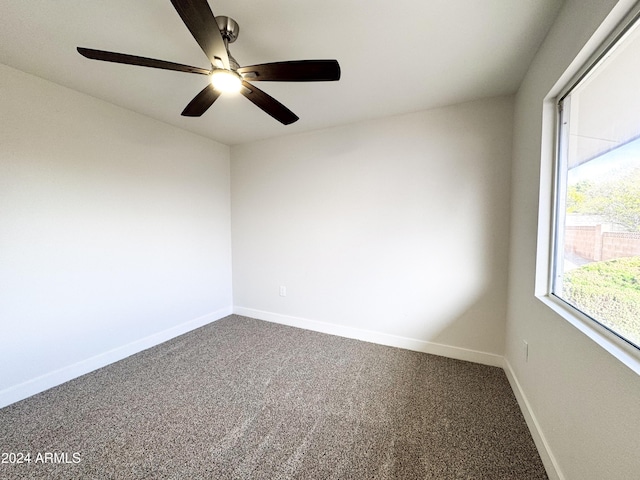 carpeted spare room featuring ceiling fan