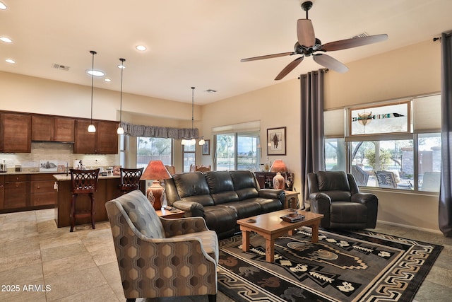 living room featuring a towering ceiling and ceiling fan