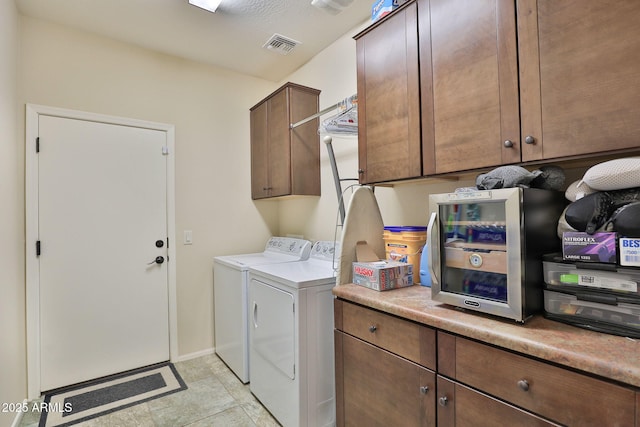 laundry room featuring cabinets and washing machine and dryer