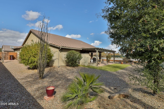 rear view of house featuring a pergola and a patio