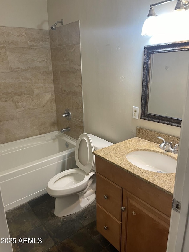 full bathroom featuring vanity, tiled shower / bath, and toilet