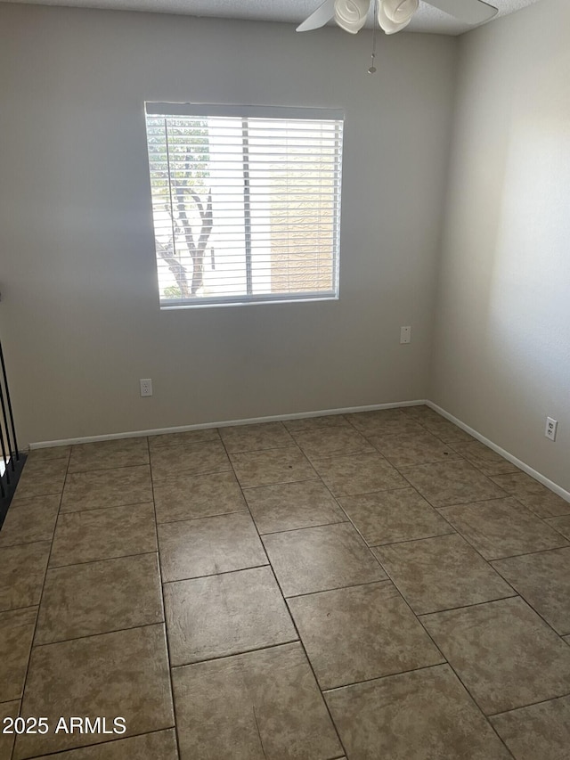 unfurnished room featuring tile patterned floors and ceiling fan