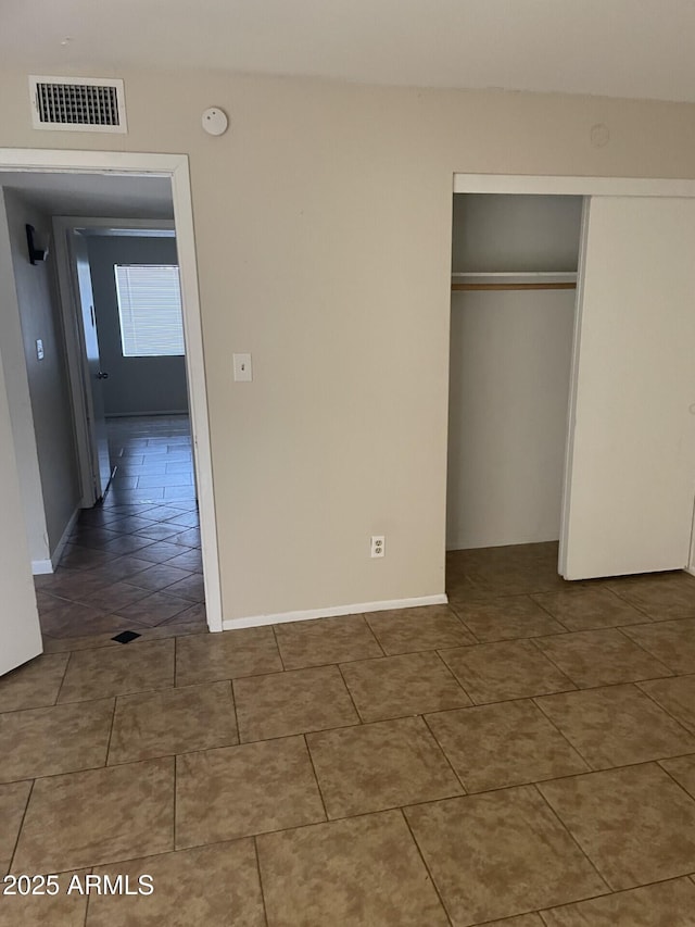 unfurnished bedroom with tile patterned floors and a closet