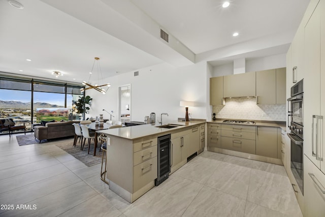 kitchen with wine cooler, pendant lighting, kitchen peninsula, sink, and appliances with stainless steel finishes