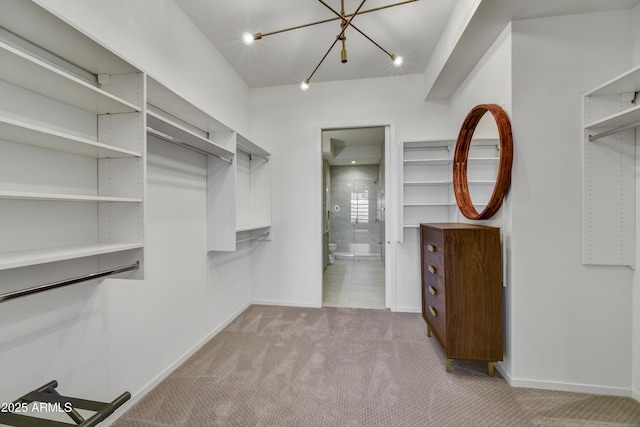 spacious closet featuring light carpet and a notable chandelier