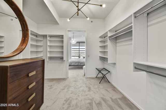 spacious closet with light colored carpet and an inviting chandelier