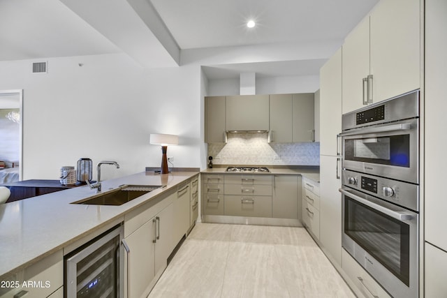 kitchen with stainless steel appliances, wine cooler, tasteful backsplash, and sink