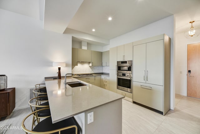 kitchen featuring appliances with stainless steel finishes, tasteful backsplash, sink, stone counters, and a breakfast bar area