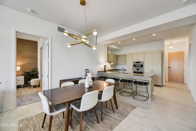 dining room featuring light tile patterned floors, a notable chandelier, and sink