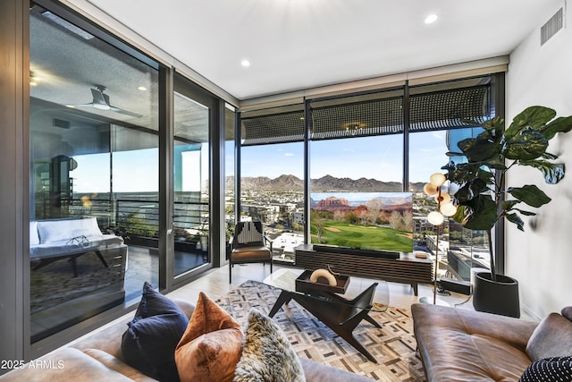 sunroom with ceiling fan and a mountain view