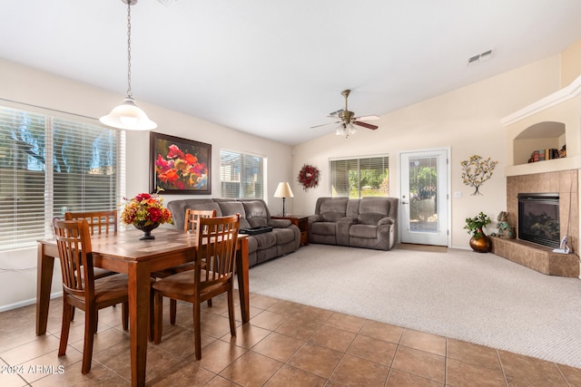 dining area featuring carpet flooring, vaulted ceiling, ceiling fan, and a fireplace