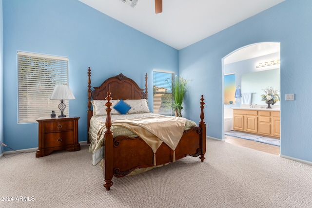 carpeted bedroom featuring ensuite bath, ceiling fan, and vaulted ceiling