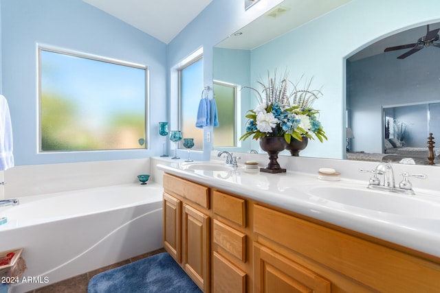 bathroom featuring ceiling fan, a bathtub, vanity, and vaulted ceiling