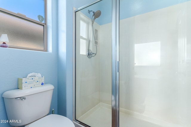 bathroom featuring toilet and an enclosed shower