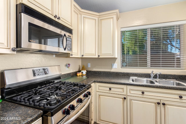 kitchen featuring cream cabinetry, sink, and appliances with stainless steel finishes