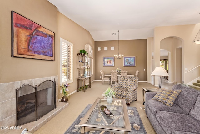 carpeted living area featuring a chandelier, stairway, arched walkways, and baseboards