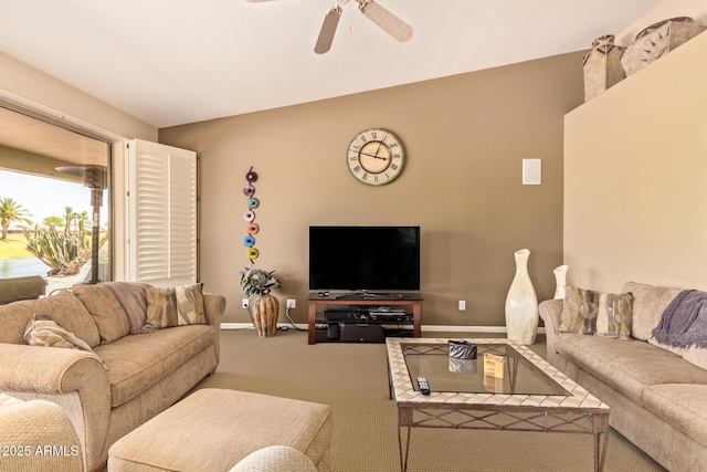 living area featuring ceiling fan, carpet floors, and baseboards