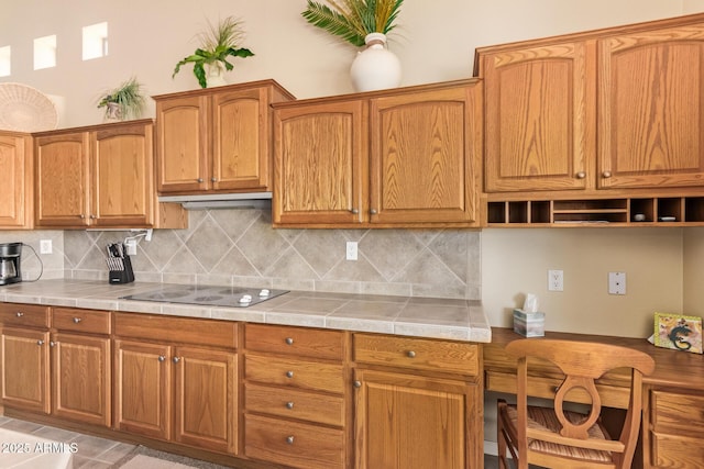 kitchen with tasteful backsplash, black electric cooktop, and brown cabinetry