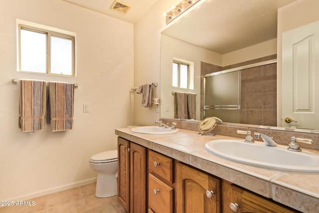 full bathroom with visible vents, a shower stall, double vanity, and a sink