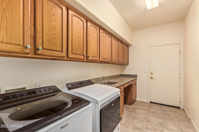 washroom featuring baseboards, independent washer and dryer, cabinet space, and a sink