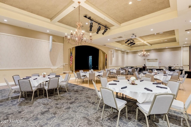 dining space with a notable chandelier, a raised ceiling, coffered ceiling, visible vents, and arched walkways