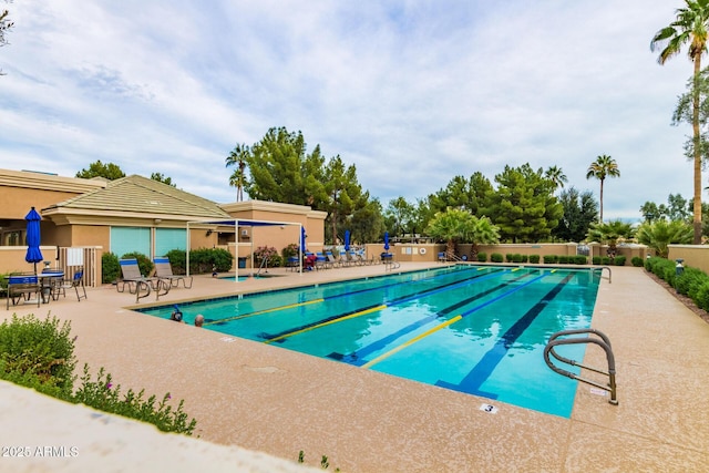 pool with a patio and fence