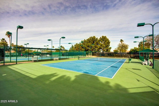 view of tennis court featuring fence