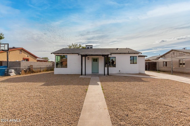 view of front of home with stucco siding and fence