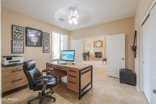 21841 N Ingram Ct, Maricopa, AZ 85138 - home office featuring a ceiling fan, light tile patterned floors, and a glass covered fireplace