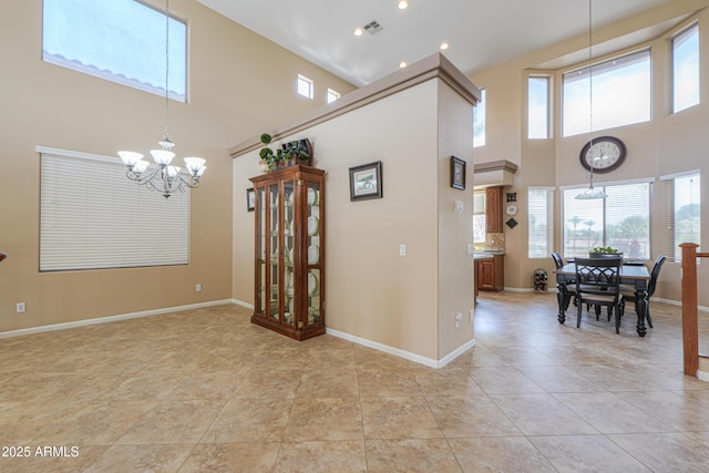 21841 N Ingram Ct, Maricopa, AZ 85138 - dining room featuring a chandelier, a towering ceiling, plenty of natural light, and light tile patterned floors