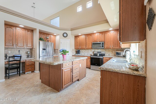 21841 N Ingram Ct, Maricopa, AZ 85138 - kitchen featuring appliances with stainless steel finishes, a sink, a center island, decorative backsplash, and a towering ceiling