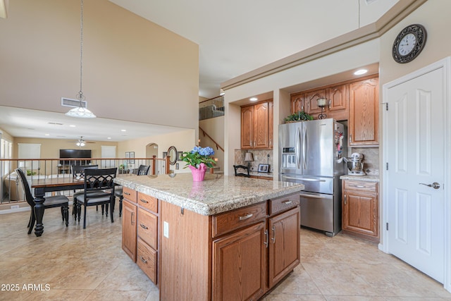 21841 N Ingram Ct, Maricopa, AZ 85138 - kitchen with stainless steel fridge, decorative backsplash, light countertops, brown cabinetry, and recessed lighting