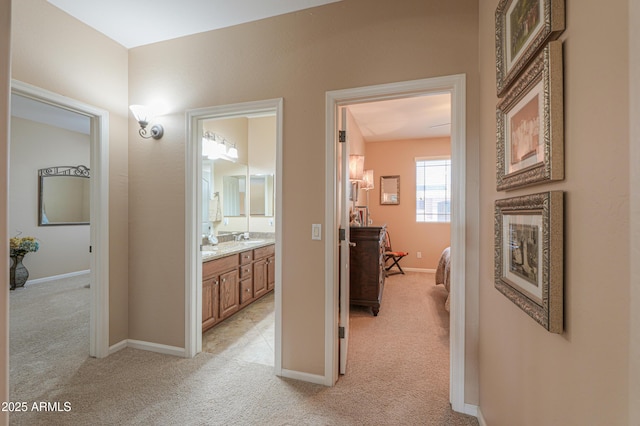 21841 N Ingram Ct, Maricopa, AZ 85138 - hallway with light carpet, a sink, and baseboards