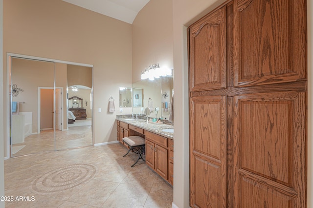 21841 N Ingram Ct, Maricopa, AZ 85138 - bathroom with double vanity, high vaulted ceiling, tile patterned flooring, baseboards, and ensuite bath
