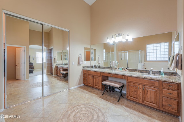 21841 N Ingram Ct, Maricopa, AZ 85138 - full bath with a towering ceiling, double vanity, a stall shower, baseboards, and tile patterned flooring